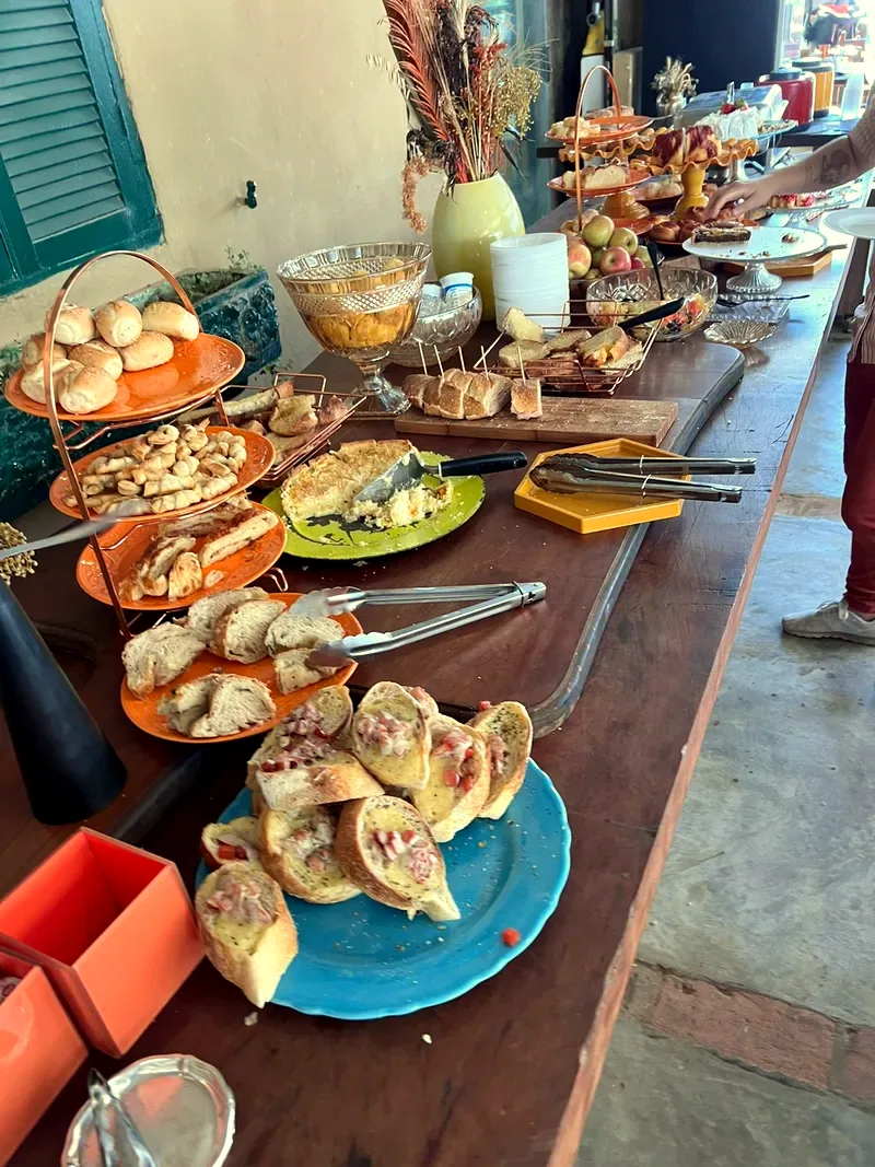 Mesa com salgados e pães da casa